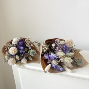 Purple and white dried flower bundles with beige ribbon bows