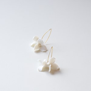 White floral drop earrings with pearl-like bead centers
