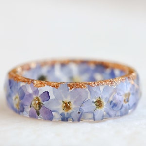 Resin floral band ring with light blue forget-me-not flowers and gold speckles