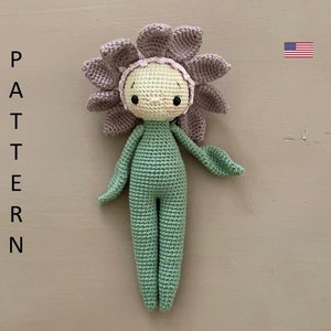 Crocheted amigurumi flower doll with purple ruffled head and green stitched body, beige face