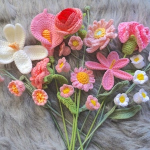 Handmade crochet bouquet with pink flowers, yellow centers, and green stems