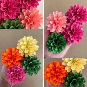 Colorful paper dahlia flowers with layered petals and green leaves