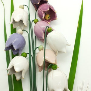 Decorative ceramic flower ornament with white and lavender bell-shaped blossoms on green stems