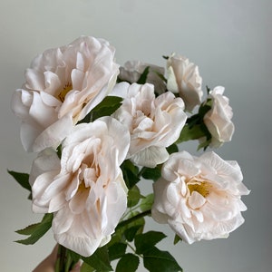 Artificial garden rose stem with white layered blooms and green leaves