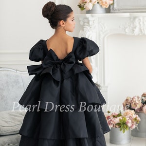 Black flower girl dress with puff sleeves, bow back, and layered skirt