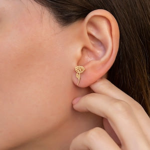 Gold-tone flower stud earrings with small drop charm