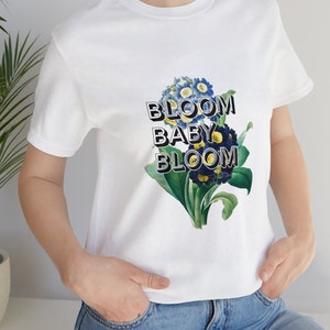 White unisex graphic tee with blue floral "Bloom Baby Bloom" print