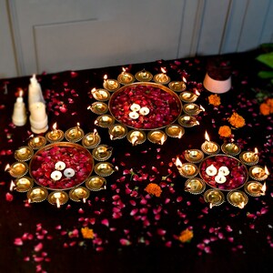 Diya-shaped urli bowl candle holder set with small tealights in gold tones