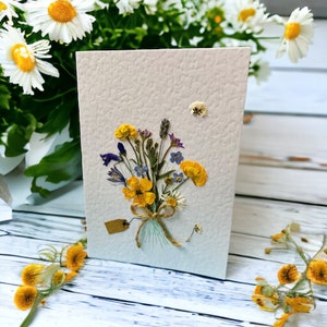 Pressed flower greeting card, off-white with yellow and blue wildflower bouquet in center