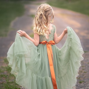 Sage green tulle flower girl dress with sleeveless bodice and orange waist sash