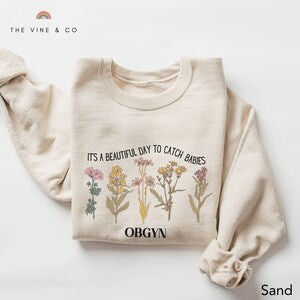 Cream OBGYN crewneck sweatshirt with vintage floral plant graphic on chest