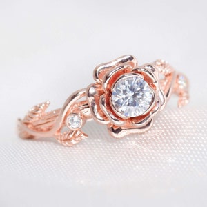 Rose floral engagement ring in rose gold with round center stone and small petal accents
