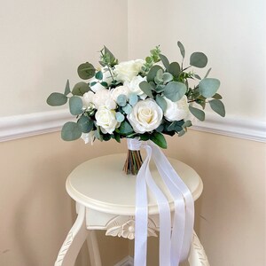 Wedding bouquet with ivory roses, eucalyptus greenery, and satin ribbon streamers