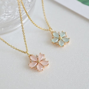 Gold-tone flower pendant necklaces with pink and teal blossom designs