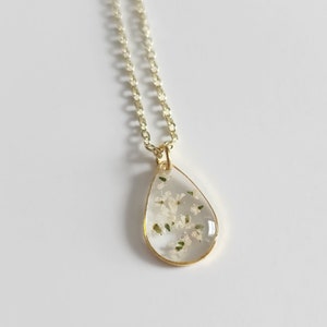 Gold teardrop pendant birth flower necklace on a delicate chain