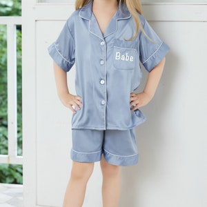 Kids light blue short-sleeve pajama set with button-up top and matching shorts, Babe print
