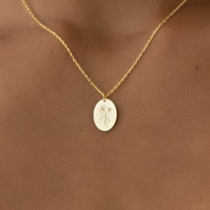 Gold birth-flower pendant necklace with round white botanical locket