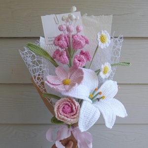 Handmade crochet flower bouquet with pink and white blossoms, rosette and ribbon wrap