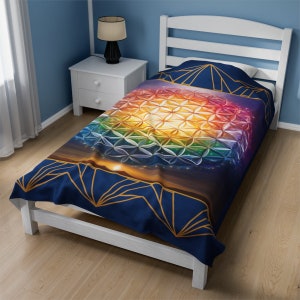 Blue velveteen throw blanket with flower-of-life geometric pattern on bed