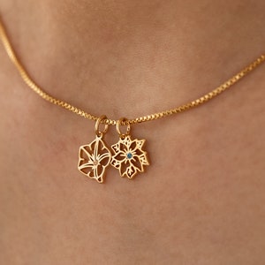 Gold-tone birth flower necklace with small linked flower charms on box chain