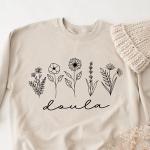 Cream doula sweatshirt with botanical flower line art and 'doula' script