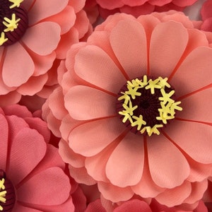 Pink paper flower decoration with ruffled petals and a yellow floral center