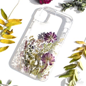 Transparent phone case with dried pressed flowers in purple and green accents