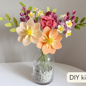 Felt flower bouquet with mixed pink, peach, cream, purple blooms in clear glass vase