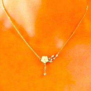 Gold floral pendant necklace with white flower charm and CZ sparkle drop