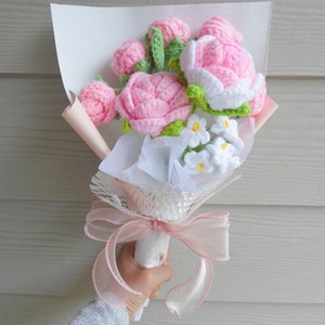 Handmade crochet flowers bouquet with pink blooms, white mini flowers, green leaves, ribbon wrap