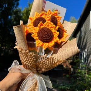 Crochet sunflower bouquet with orange petals and brown center, wrapped in paper and clear wrap