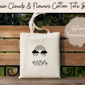 Off-white cotton tote bag with black rainbow and cloud graphic, top handles