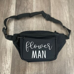 Black waist bag with zippered front pocket and 'Flower MAN' print