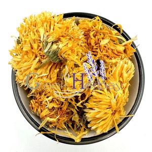 Dried calendula marigold flower petals in black bowl for herbal tea