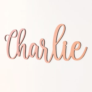 Wooden name sign with cursive 'Charlie' lettering, pink outline