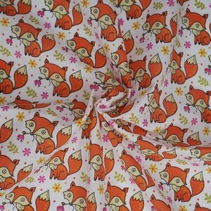 White polycotton fabric with orange foxes and small pink flowers, rolled edge