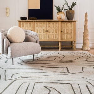 Hand-tufted off-white rug with gray abstract line pattern, rectangular