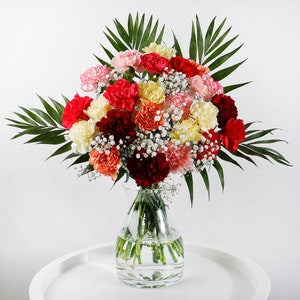 Multicolor carnation bouquet with mixed blooms in clear glass vase