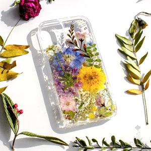 Clear phone case with pressed flowers bouquet in blue, yellow, and pink