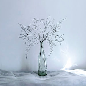 Green glass vase with steel wire eternal flowers and branching stems, home decor