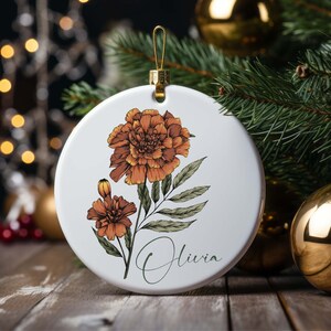 White round birth flower ornament with brown flower, leaves, and Olivia name