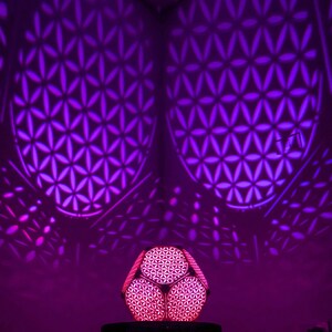 Flower of Life geometric LED night light glowing purple, round lantern base