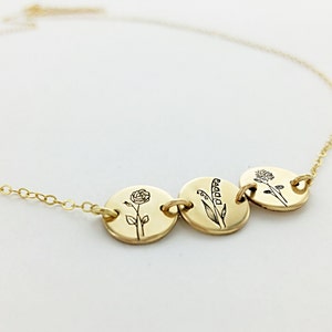 Gold-tone birth flower disk necklace with three engraved flower medallions on chain