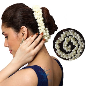 White jasmine hair garland worn on dark hair bun, with close-up detail