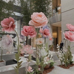 Giant flower backdrop with pink and white oversized blooms on tall stems