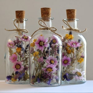 Glass jars with cork lids filled with dried wildflowers for decor
