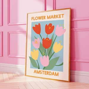 Framed tulip floral wall art print with 'FLOWER MARKET AMSTERDAM' text and orange-pink-blue flowers