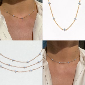 Dainty gold chain necklace with small flower charm and delicate bead-like links