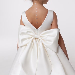 Ivory satin flower girl dress with bow-front bodice and open V-back