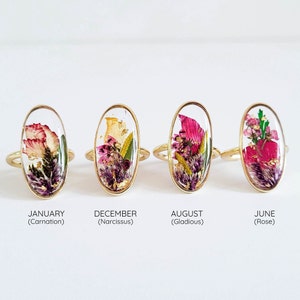 Gold-tone oval resin birth-flower ring with dried florals, January/December/August/June labels